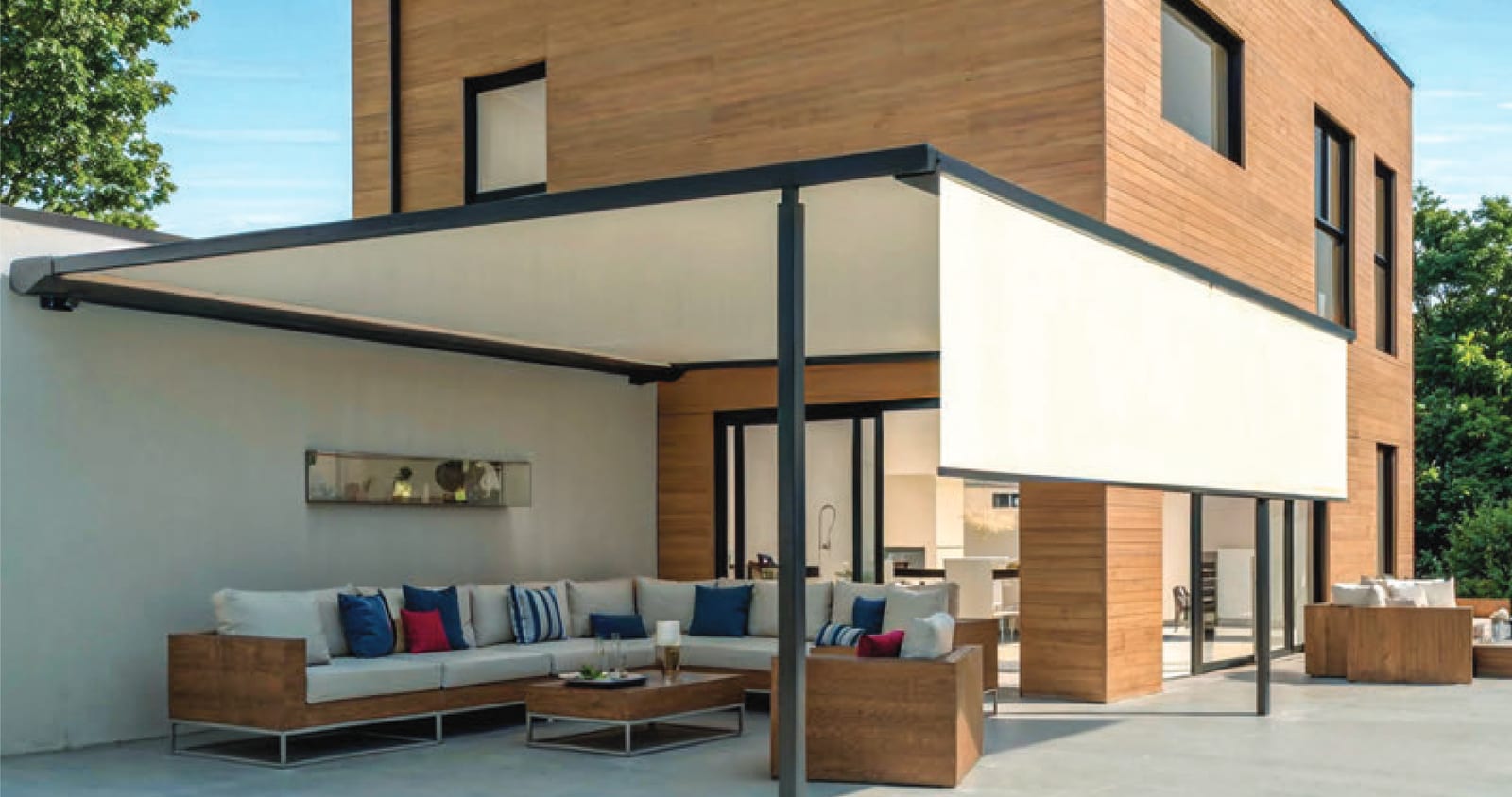 Pergolamarkise mit Pfosten über einer Lounge-Terrasse an einem Holzhaus
